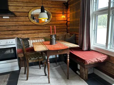 a dining room with a table and a mirror at Old Farmhouse Retreat with jacuzzi and sauna in Eidsvoll
