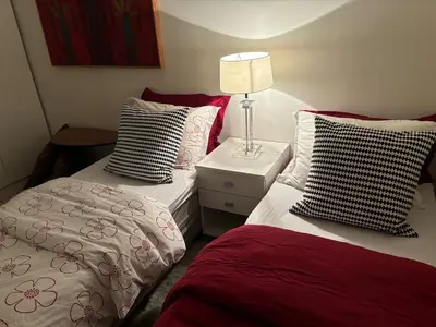 a bedroom with two beds and a lamp on a night stand at Leilighet Rjukan sentrum in Rjukan