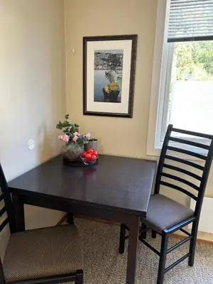 a black dining room table with two chairs and flowers at Leilighet Rjukan sentrum in Rjukan