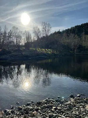 a river with the sun reflecting in the water at Cozy cabin in Eikedalen in Eikedalen
