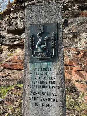 a statue of a man sitting on a stone grave at Cozy cabin in Eikedalen in Eikedalen