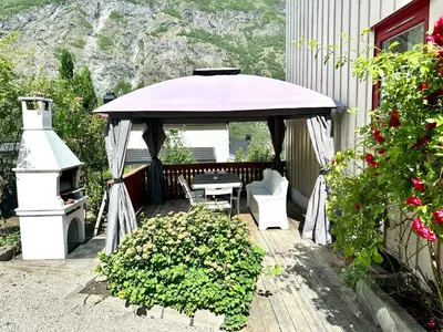 a gazebo with a table and chairs on a patio at FjordNest Årdalstangen in Årdalstangen