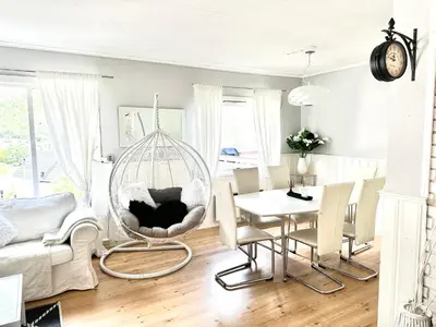 a living room with a swing chair and a table at FjordNest Årdalstangen in Årdalstangen