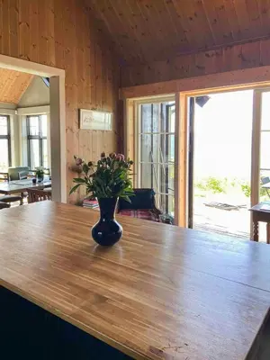 a vase with flowers sitting on a wooden table at Private Cabin With Stunning Views Near Oslo in Eina