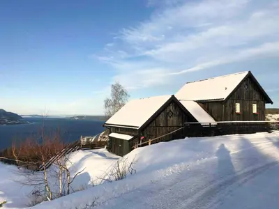 a wooden barn with snow on its roof at Private Cabin With Stunning Views Near Oslo in Eina