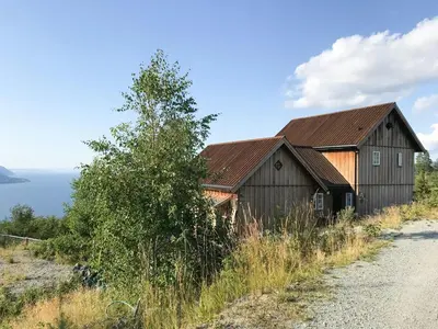 a barn on a hill next to a road at Private Cabin With Stunning Views Near Oslo in Eina
