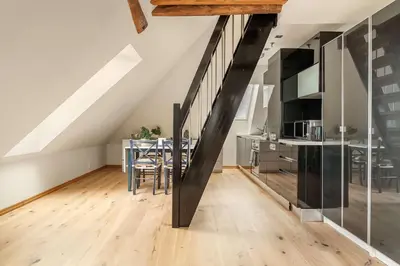 a kitchen and dining room with a staircase in a loft at DINBNB Apartments l 200m to Bryggen l Luxury 2 BR l 2min to Floibanen in Bergen