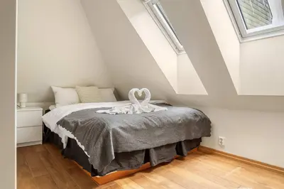 a bedroom with a bed in a attic at DINBNB Apartments l 200m to Bryggen l Luxury 2 BR l 2min to Floibanen in Bergen