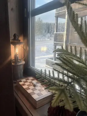 a window with a chess board next to a christmas tree at Modern mountain apartmen Ski in and out in Trysil