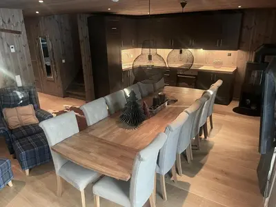 a dining room table with chairs and a kitchen at Modern mountain apartmen Ski in and out in Trysil