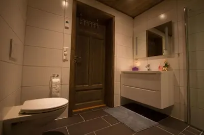 a bathroom with a toilet and a sink and a door at Modern mountain apartmen Ski in and out in Trysil