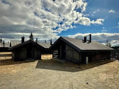 two wooden buildings with a sky with clouds at Modern mountain cabin Ski in-out 2 Bathrooms in Ringsaker
