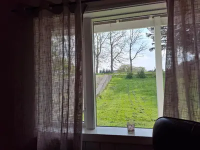 a window with a view of a field of grass at Apartment in the heart of Sunnmore in Vigra