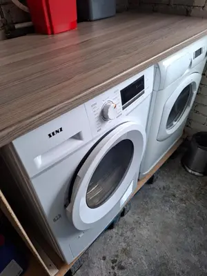 a white washing machine sitting under a counter at Apartment in the heart of Sunnmore in Vigra