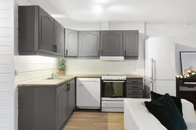 a kitchen with gray cabinets and a white refrigerator at Staymate apartments. Trondheim sentrum in Trondheim