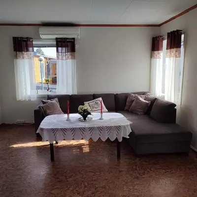 a living room with a couch and a table with two candles at Leilighet nær E4 i sentrum av Eina in Eina