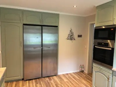 a kitchen with a refrigerator and a christmas tree on the wall at Magnhilds Luxury Apartment in Otta