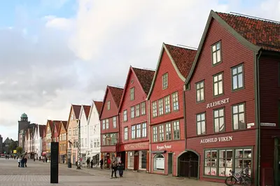 a row of red and white buildings on a street at CozyStay Beside Historic Bryggen in Bergen