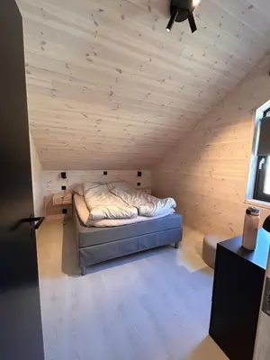 a bed in a room with a wooden ceiling at Rinden cabin in Sogndal