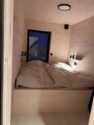 a bed in a small room with a window at Rinden cabin in Sogndal