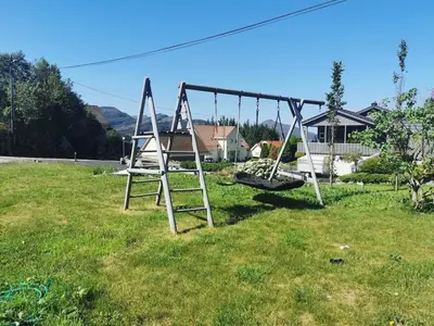 an empty swing set in a yard at Fjordgløtt in Blålia