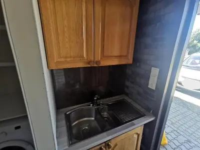 a kitchen with a sink and wooden cabinets at Fjordgløtt in Blålia