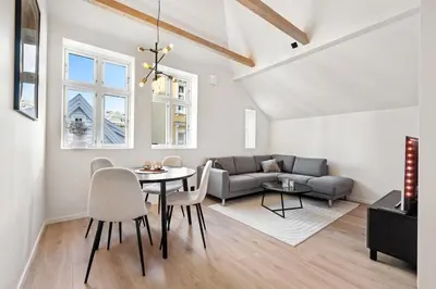 a living room with a table and a couch at Newly renovated apartment in the heart of Bergen city center in Bergen