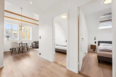 a bedroom with a bed and a table in a room at Newly renovated apartment in the heart of Bergen city center in Bergen