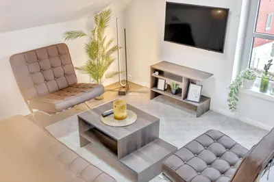 a living room with two chairs and a tv at Heimby - Seaside Luxury - Free Parking in Bergen
