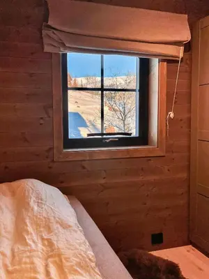 a bedroom with a window in a log cabin at Modern Family Cabin By Tempelseter Ski Trails in Eggedal