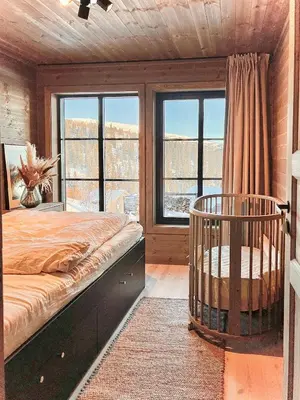 a bedroom with a bed and a large window at Modern Family Cabin By Tempelseter Ski Trails in Eggedal