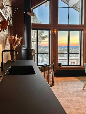a kitchen with large windows and a counter with a sink at Modern Family Cabin By Tempelseter Ski Trails in Eggedal