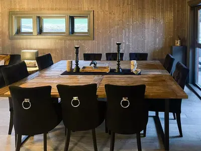a dining room with a wooden table and chairs at Mountain Escape Near Gulsrud With Historical Charm in Eggedal