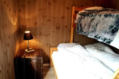 a bedroom with two beds and a lamp on a night stand at Ski-in ski-out high standard cabin, 3 bedroom in Oppdal