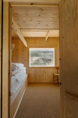 a bedroom with a bed in a wooden house at Architect designed sleeping box in barn in Nos