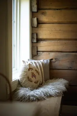 a bed with a pillow and a window in a room at Tømmerhuset på Brekketunet in Stryn