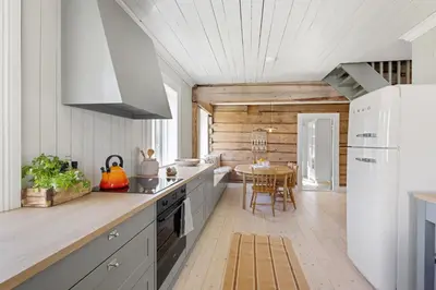 a kitchen with white cabinets and a table in it at Tømmerhuset på Brekketunet in Stryn