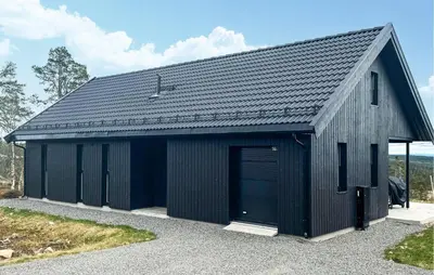 a black garage with a black roof at Amazing Home In Løten in Løten