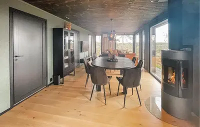 a dining room with a table and a fireplace at Amazing Home In Løten in Løten