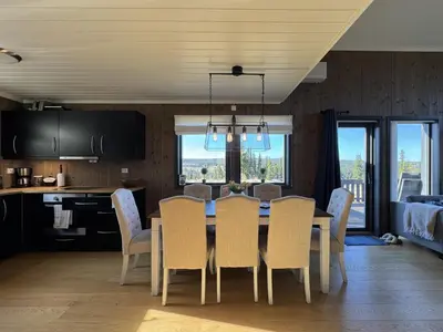 a kitchen and dining room with a table and chairs at Modern mountain cabin in Tisleidalen, Golsfjellet in Gol
