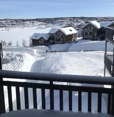 a yard covered in snow with houses in the background at Ski-in ski-out at Kikut, Geilo, apartment with sauna in Geilo