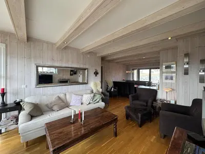 a living room with a white couch and a table at Ski-in ski-out at Kikut, Geilo, apartment with sauna in Geilo