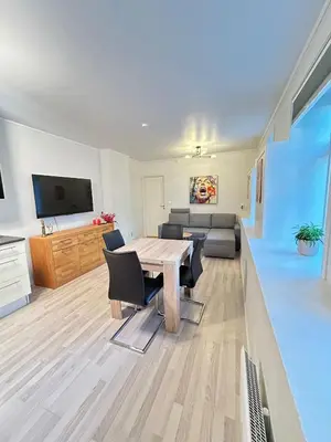 a living room with a table and chairs and a couch at Apartment in the Heart of Ålesund in Ålesund
