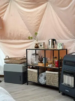 a room with aige tent with a shelf with items at Idyllisk overnatting i dome ved sandstrand in Langenes