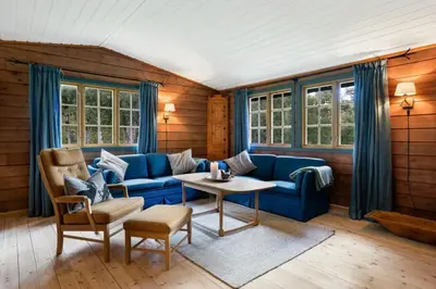 a living room with a blue couch and a table at Mountain Cabin With Cross-Country Trails In Rauland in Rauland
