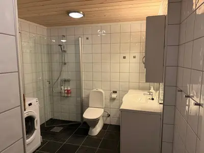 a bathroom with a toilet and a sink and a washing machine at Apartment with a view at Bavallen Tråstølen Voss in Vossevangen