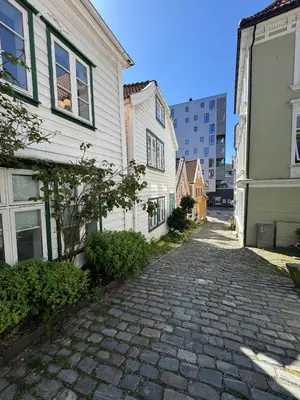 a cobblestone street between two buildings in a city at Bo i Bergens eldste smau på Nøstet - sentralt og rolig in Bergen
