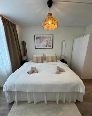 a bedroom with a large white bed with towels on it at Bo i Bergens eldste smau på Nøstet - sentralt og rolig in Bergen