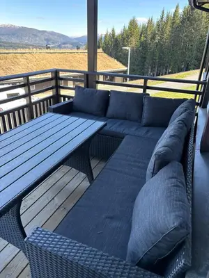 a blue couch and a table on a deck at Modern apartment in Voss in Vossevangen