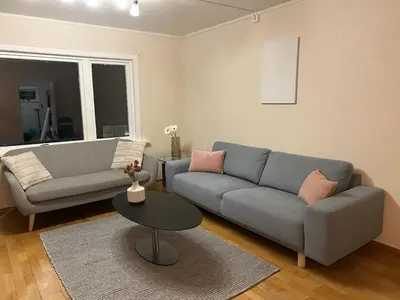 a living room with a couch and a table at Spacious 3 Bedroom Townhouse in Bergen